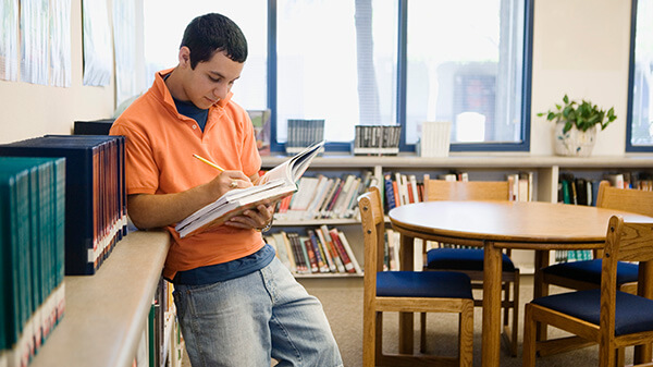 Boy Studying in College Library