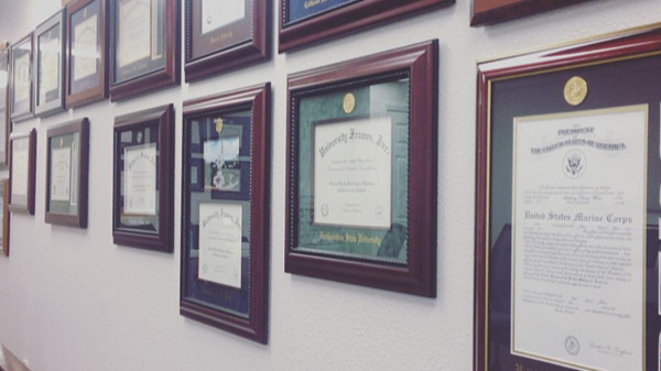 hanging diplomas on wall